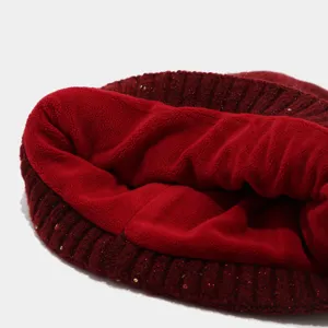 Primer plano de gorro de punto rojo de invierno con forro polar suave y lentejuelas.