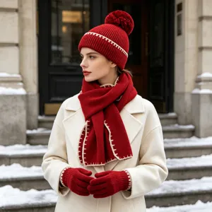 Conjunto de gorro, bufanda y guantes de punto rojo con detalles contrastantes de invierno.