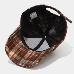 Vintage distressed plaid baseball cap with raw edge, casual brown fashion hat detail view.
