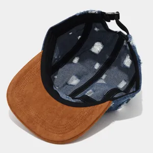 Detalle interior de gorra de 5 paneles de mezclilla desgastada con visera de gamuza.