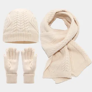 Vista detallada de la textura suave y el tejido del conjunto de gorro bufanda y guantes de punto.