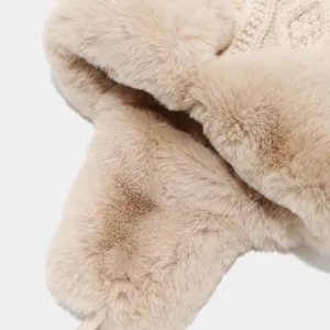 Primo piano dettaglio di cappello invernale pelliccia beige con morbido peluche e maglia.
