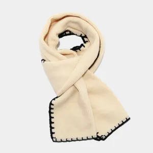 Cálida bufanda de punto beige con elegantes costuras en contraste negro para invierno.