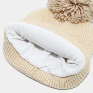 Primer plano del acogedor gorro de invierno con detalle de forro de polar blanco.