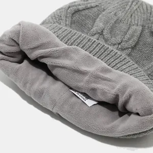 Primer plano detallado de gorro de punto gris con forro polar suave y etiqueta.