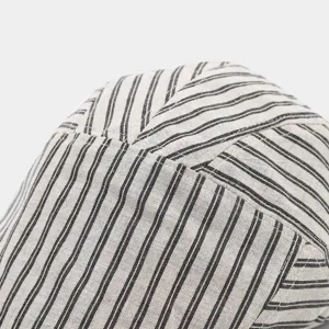 Gros plan sur les détails de la casquette plate rayée rétro, texture en lin de qualité.