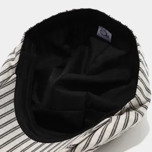 Gros plan sur la doublure intérieure de la casquette plate rayée et sa texture de tissu.