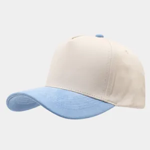 Detail view of a stylish color-block baseball cap featuring beige crown and light blue suede brim.