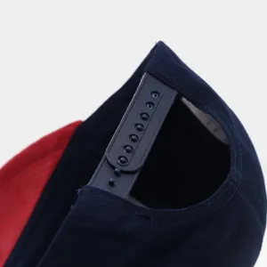 Adjustable snapback baseball cap detail, colorblock design, navy blue and red streetwear hat.