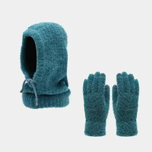 Dettaglio del cappuccio balaclava in maglia verde scuro e guanti caldi coordinati.