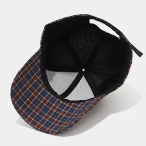 Interior detail of retro plaid baseball cap showing fine stitching and adjustable metal buckle.