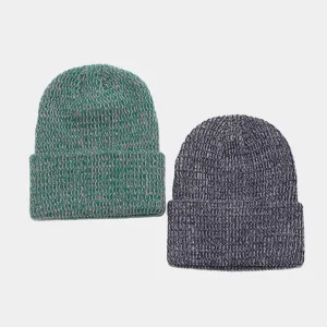 Primer plano detallado de cómodos gorros de punto jaspeado en verde y azul oscuro para invierno.