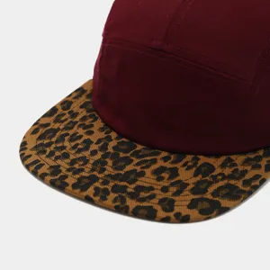 Leopard print brim detail of five-panel flat brim cap in burgundy and brown tones.
