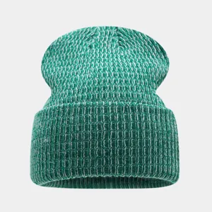 Vista detallada del gorro de punto jaspeado en verde y blanco, cálida textura de invierno.