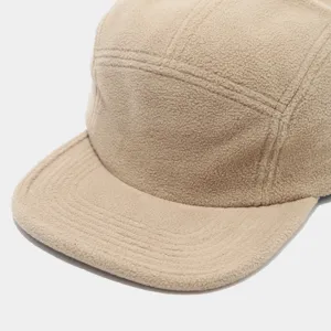 Nahaufnahme der Textur und Nahtdetails einer gemütlichen Beigen Fleece 5-Panel Kappe.
