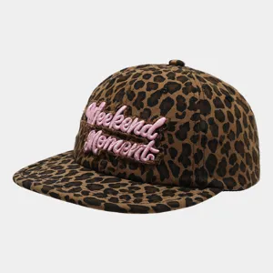 Closeup of the leopard print hip-hop cap featuring pink embroidered patch text detail.