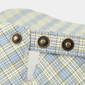 Plaid sun visor detail view, metal snap button closure and fine stitching craft showcase.