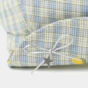 Close-up of women summer plaid ivy cap featuring silver bow star pendant and yellow embroidery.