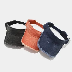 Detailed view of washed denim sun visors featuring vintage frayed edges and adjustable straps.