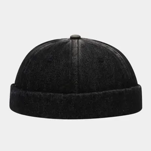Black washed denim docker cap detail, brimless street style hat closeup showing texture.