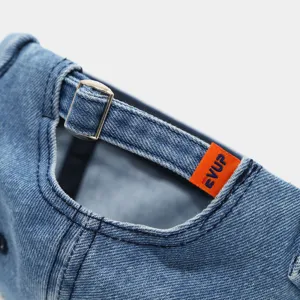 Close-up detail of the adjustable strap and woven tag on the stylish washed denim docker hat.