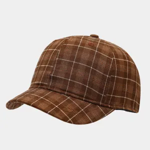 Close-up detail of the brown plaid short brim baseball cap, showcasing vintage fabric texture.