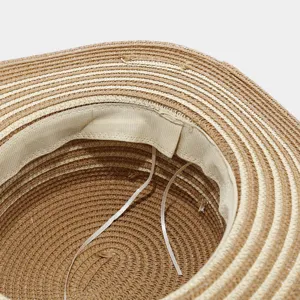 Vista detallada del sombrero de paja para mujer, mostrando la textura y banda interior.