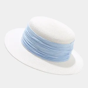 Details of French vintage flat top straw hat with light blue ribbon for summer beach.