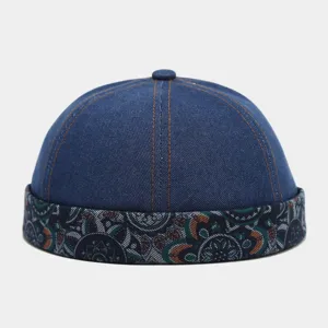 Detail shot of a retro washed denim docker cap with a stylish paisley brim and orange stitches.