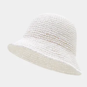 Detailed close-up of white hollow straw bucket hat, breathable texture summer sun hat.
