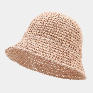 Detail view of the hollow-out straw bucket hat, showing the breathable woven texture and beige color.