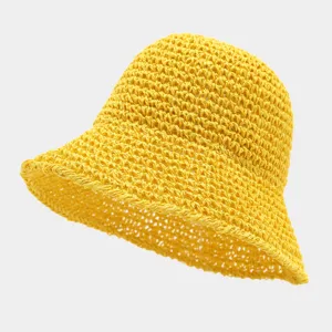 Detail view of a vibrant yellow straw bucket hat, featuring a breathable woven design for summer.