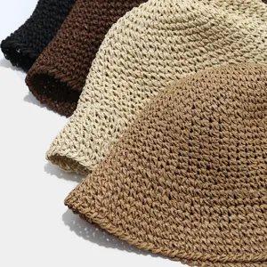 Close-up detail of hollow straw bucket hats in multiple colors, breathable summer beach wear.