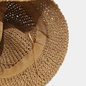 Close-up detail of the brown woven straw hat, showing breathable hollow-out texture clearly.