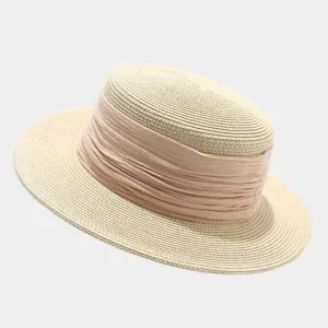 Close-up detail of the French vintage flat top straw hat with wide ribbon for summer beach wear.