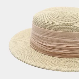 Straw hat detail view showcasing fine woven texture and elegant pink ribbon decoration.