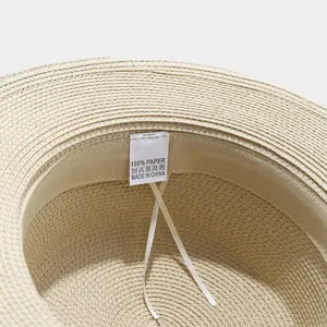 Straw hat interior detail showcasing 100% paper material and fine woven summer texture.