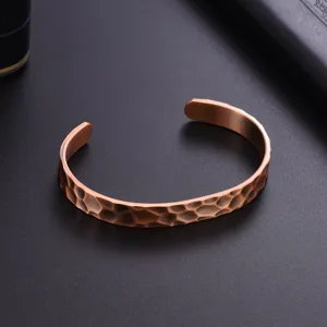 Detailed view of a vintage hammered copper cuff bracelet with an open design and textured finish.