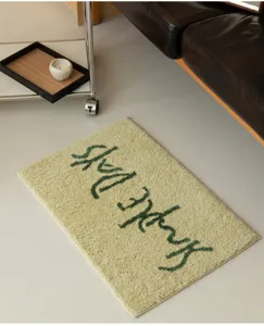 Detailaufnahme der flauschigen minimalistischen grünen Badematte mit dekorativem Webmuster.