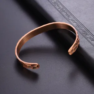 Detailed shot of hammered copper open cuff bracelet, vintage metal texture jewelry design.