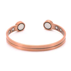 Primer plano detallado del brazalete magnético de cobre vintage con acabado texturizado.