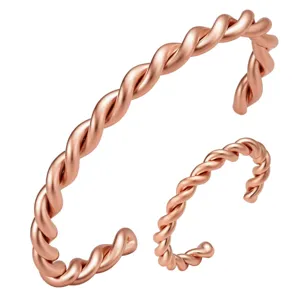 Detail view of rose gold twisted open cuff bracelet and matching ring set, elegant design.