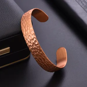 Detailed close-up of a stylish hammered pure copper cuff bracelet, adjustable open design.