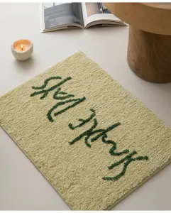 Minimalistische dicke Badematte saugfähig mit grünem Tufting-Schriftzug für gemütliches Zuhause.