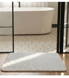Primer plano detallado de la alfombrilla de baño blanca y suave situada en un baño moderno.