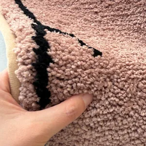 Pink fluffy bath mat close-up texture display, soft absorbent anti-slip bedroom floor carpet.