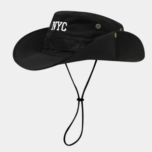 Close-up details of the black bucket hat showcasing white NYC embroidery and chin strap.