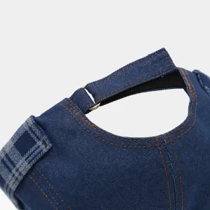 Detailed view of vintage blue denim docker cap featuring contrast stitching and side plaid patch.