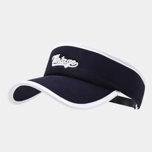 Dettaglio in primo piano del cappello da sole blu marino con bordo bianco e ricamo vintage.