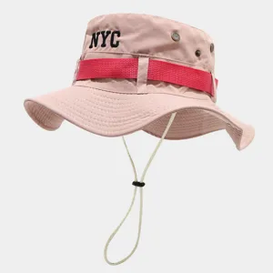 Pink outdoor bucket hat detail featuring NYC embroidery, red strap and adjustable chin cord.